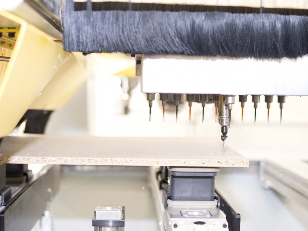 Moderne CNC-Technik in der Werkstatt | Tischlerei Bexter CNC-Maschine bearbeitet eine Holzplatte in der Tischlerei-Werkstatt